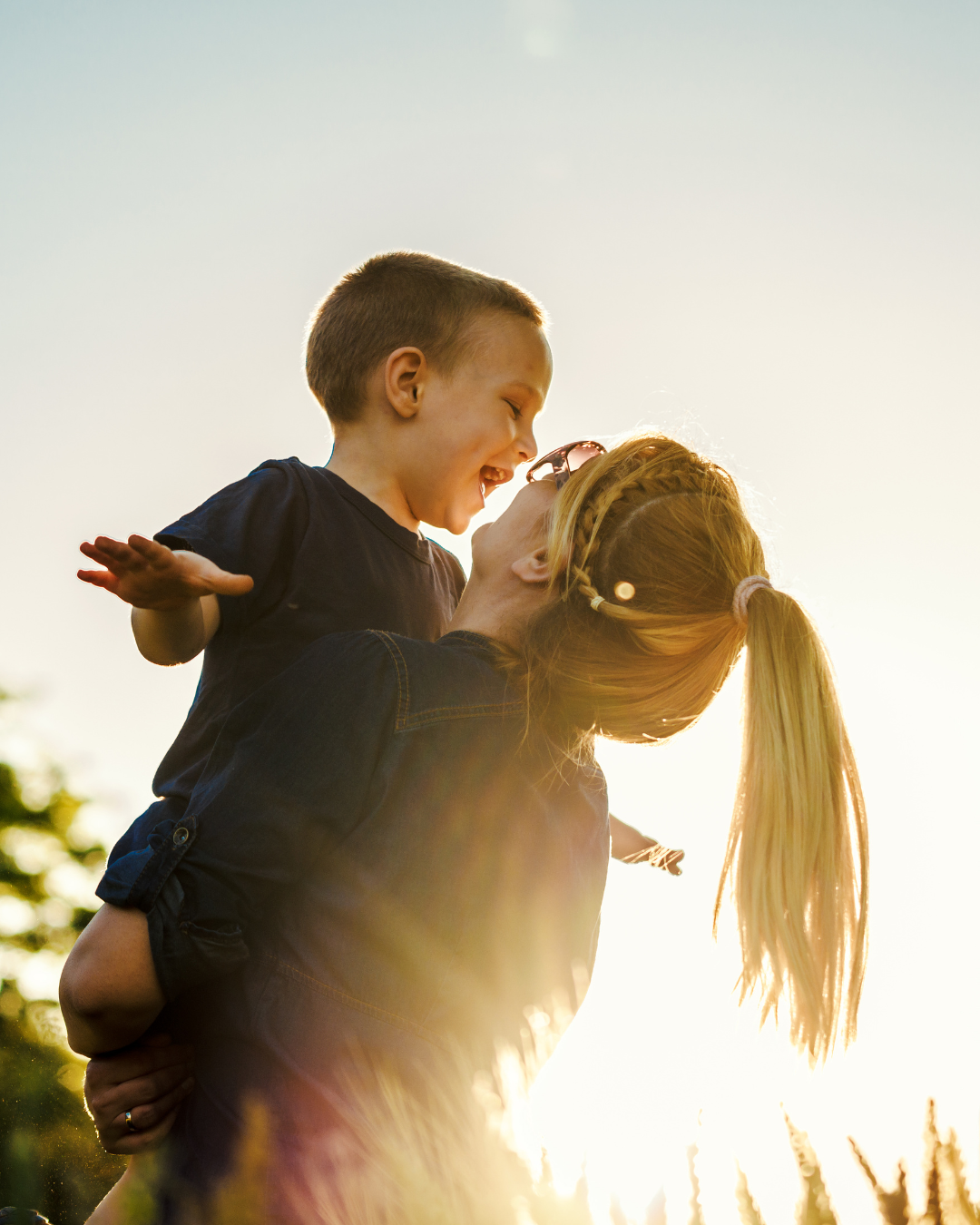 Mãe abraçando o filho ao pôr do sol